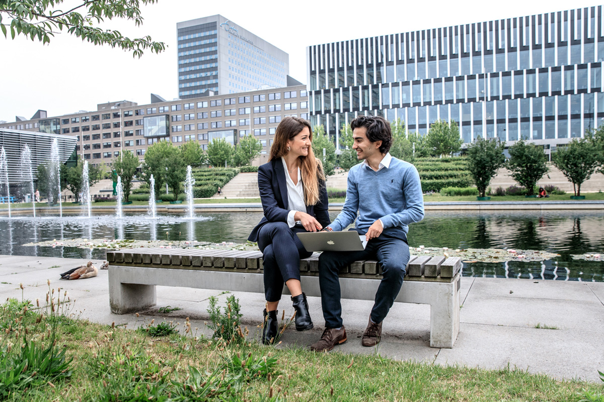 Students sitting on bench on Woudestein campus