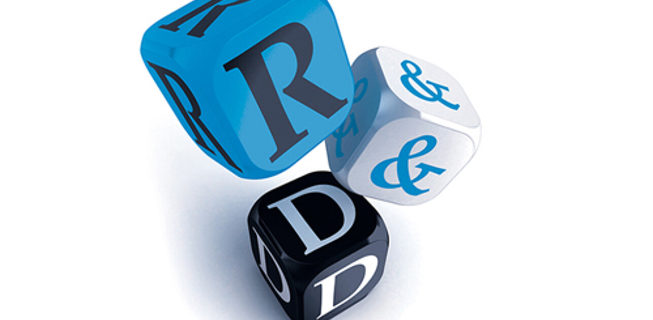 Three dice captured mid-fall, displaying the letters 'R', '&', and 'D' to spell out 'R&D'.