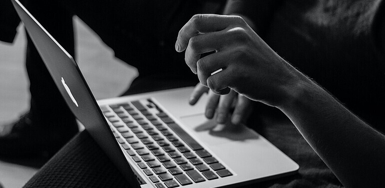 Hands typing on a macbook