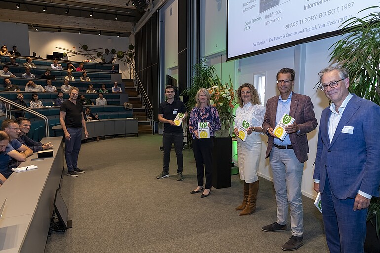 A photo shows people on the stage presenting book Technologie en Tulpen 