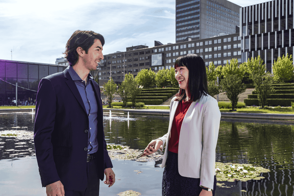 female and male students talking in front of lake on woudestein campus 