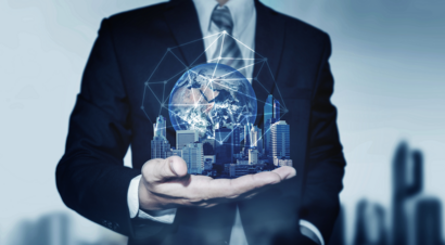 Elegant man holding a skyline of skyscrapers connected to a globe in his palm, symbolizing corporate responsibility.