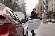 a man stepping out of an electric car