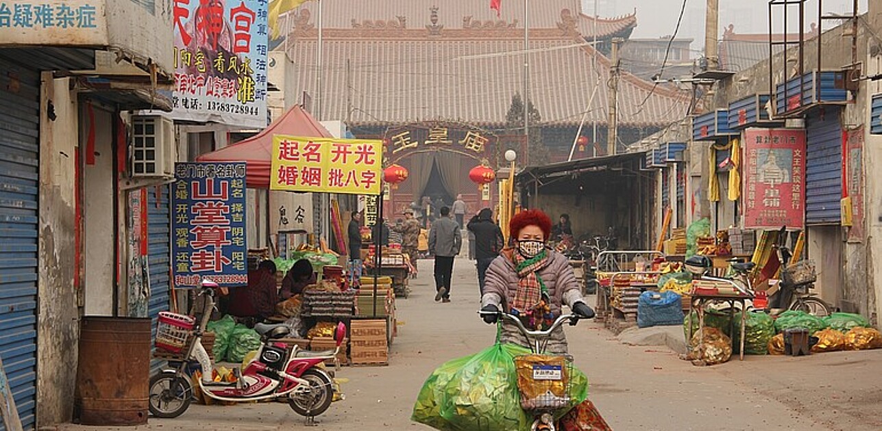 Woman with bags on bicycle in asia