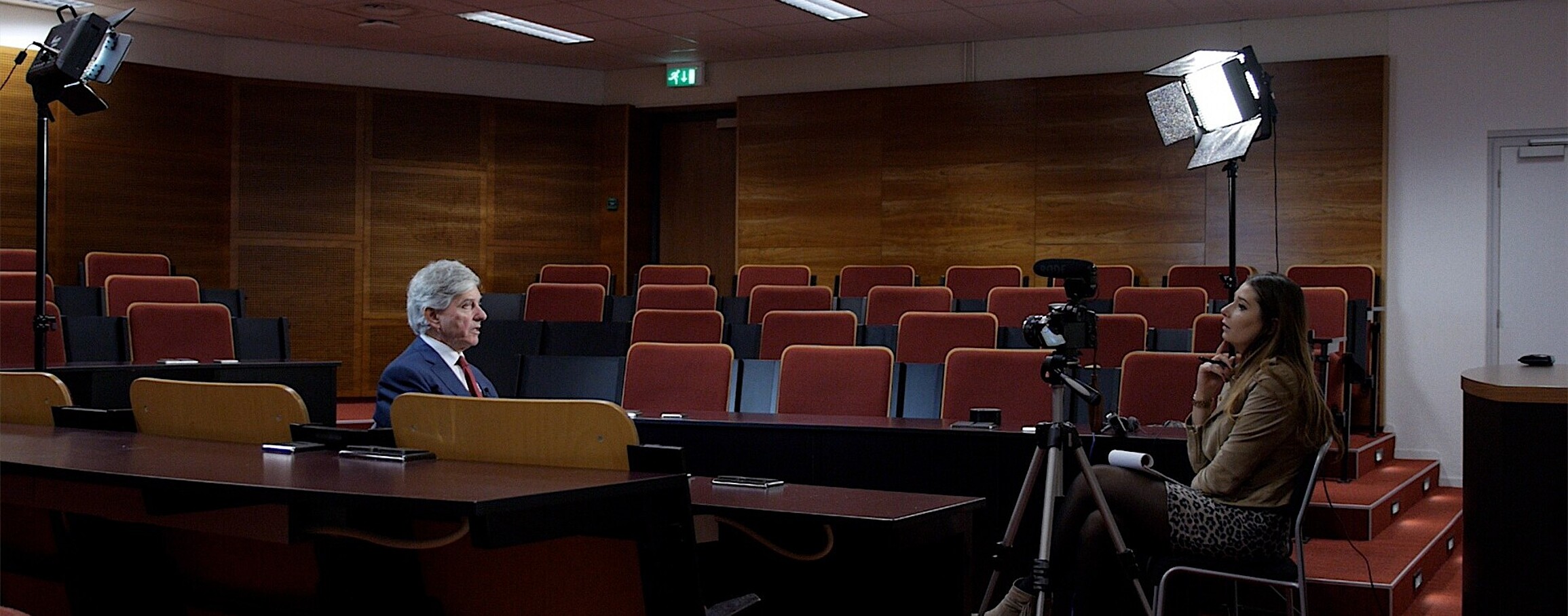 A man in suit being interviewed by a woman