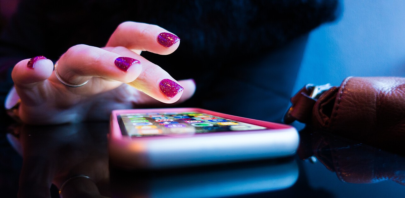 A photo shows woman's hand clicking on the app on the phone