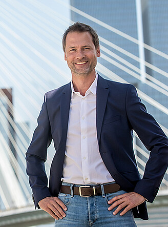 Elegant man posing in front of the Erasmus Bridge in Rotterdam