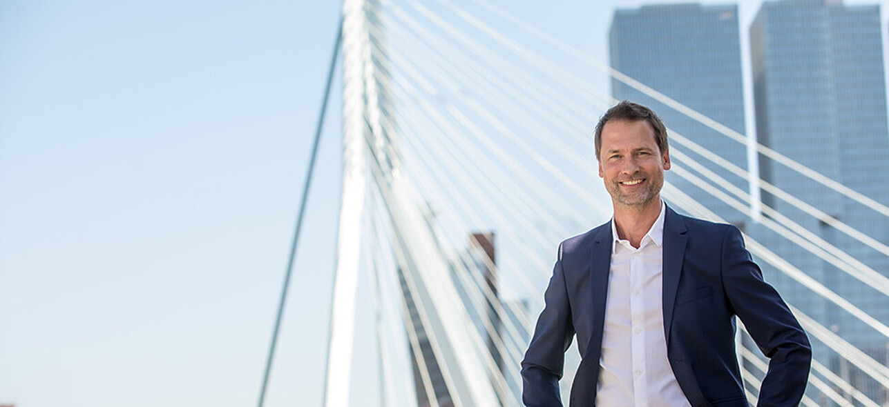 Man standing in front of famous erasmus bridge