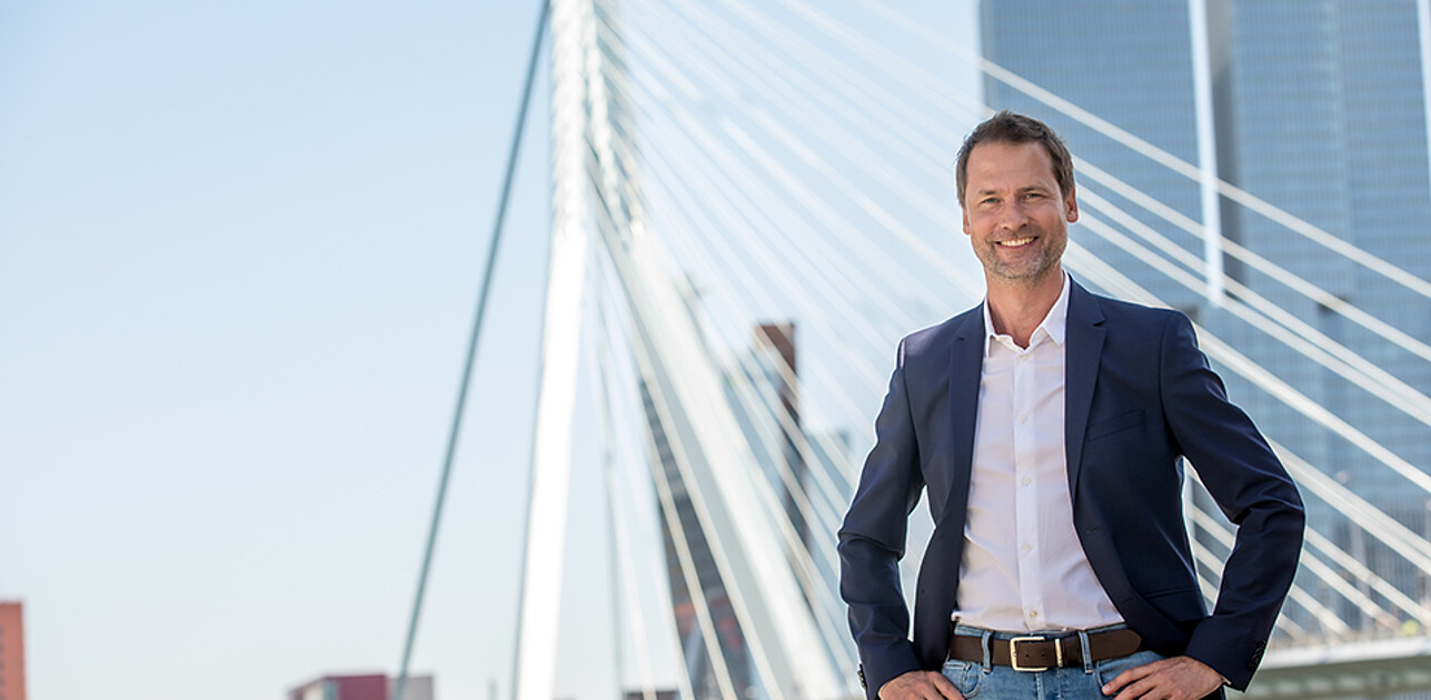 Elegant man posing in front of the Erasmus Bridge in Rotterdam