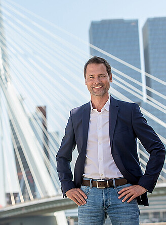 Elegant man posing in front of the Erasmus Bridge in Rotterdam