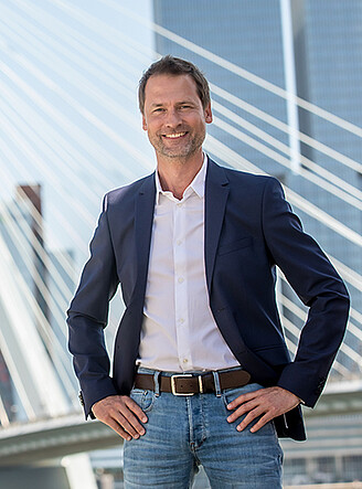 Elegant man posing in front of the Erasmus Bridge in Rotterdam