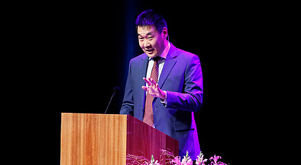 A picture of Mirko speaking at a graduation ceremony