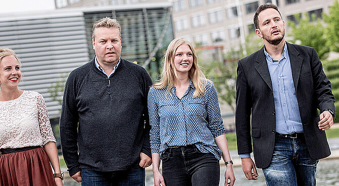 4 PhD students walking next to each other on campus