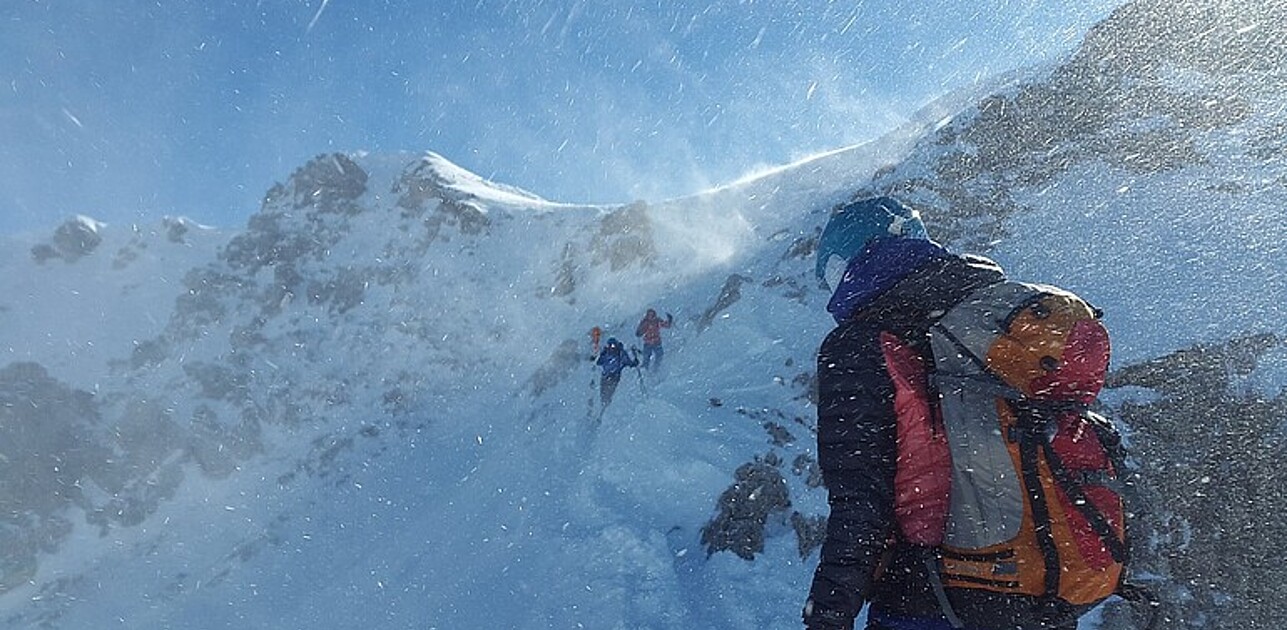 People hiking through snowy mountains.