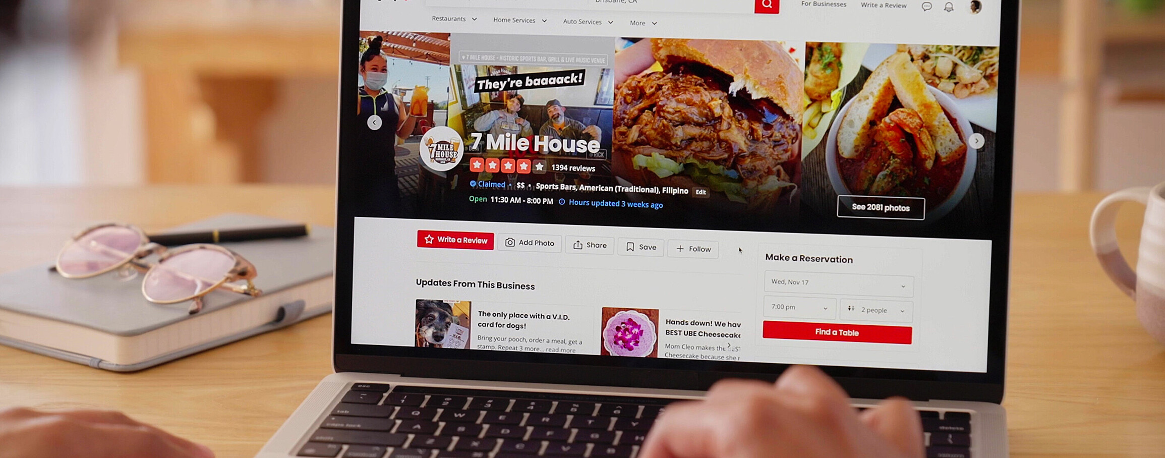 A photo shows a laptop with review site on screen