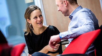 Two part-time phd students in classroom, talking