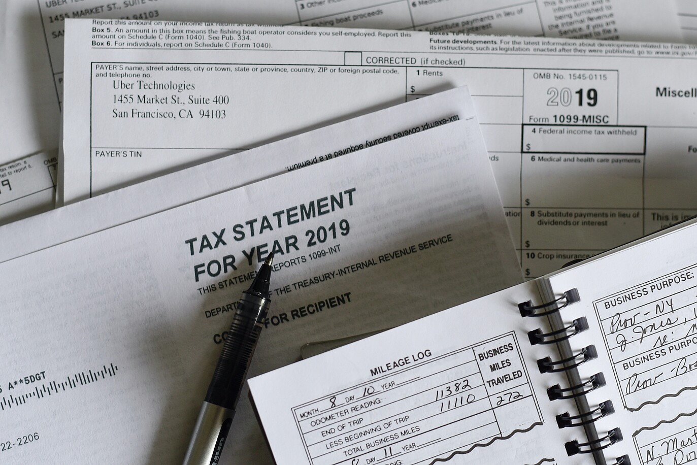 An image shows a pile of documents with tax statements