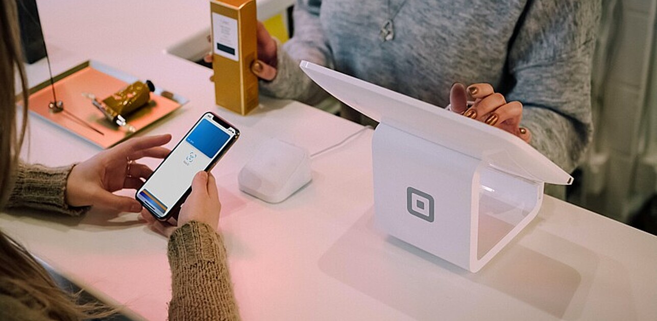 Women paying in store via apple pay.