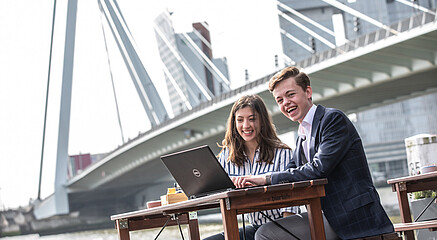 Students sitting in front of Erasmus bridge