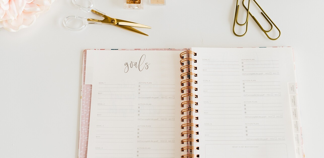 Open notebook displaying handwritten personal goals on its pages.