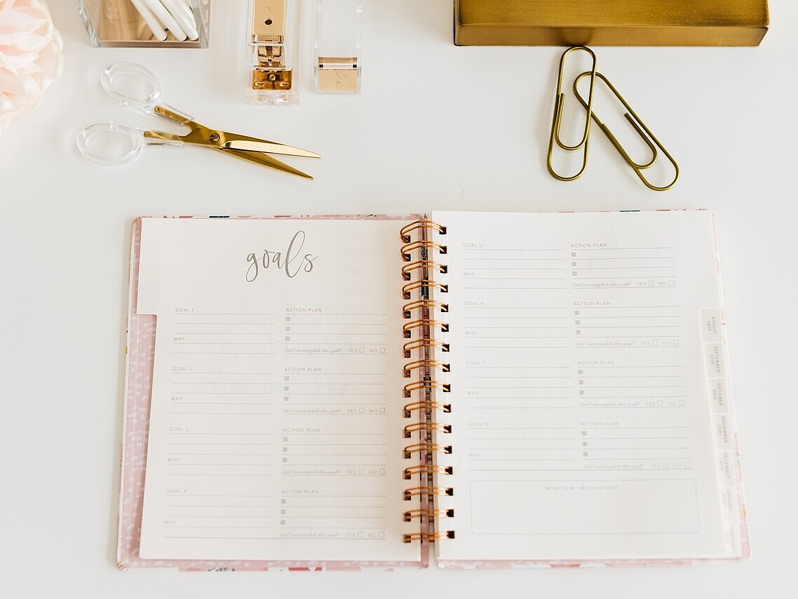 Open notebook displaying handwritten personal goals on its pages.