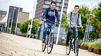 Two students on bikes at RSM