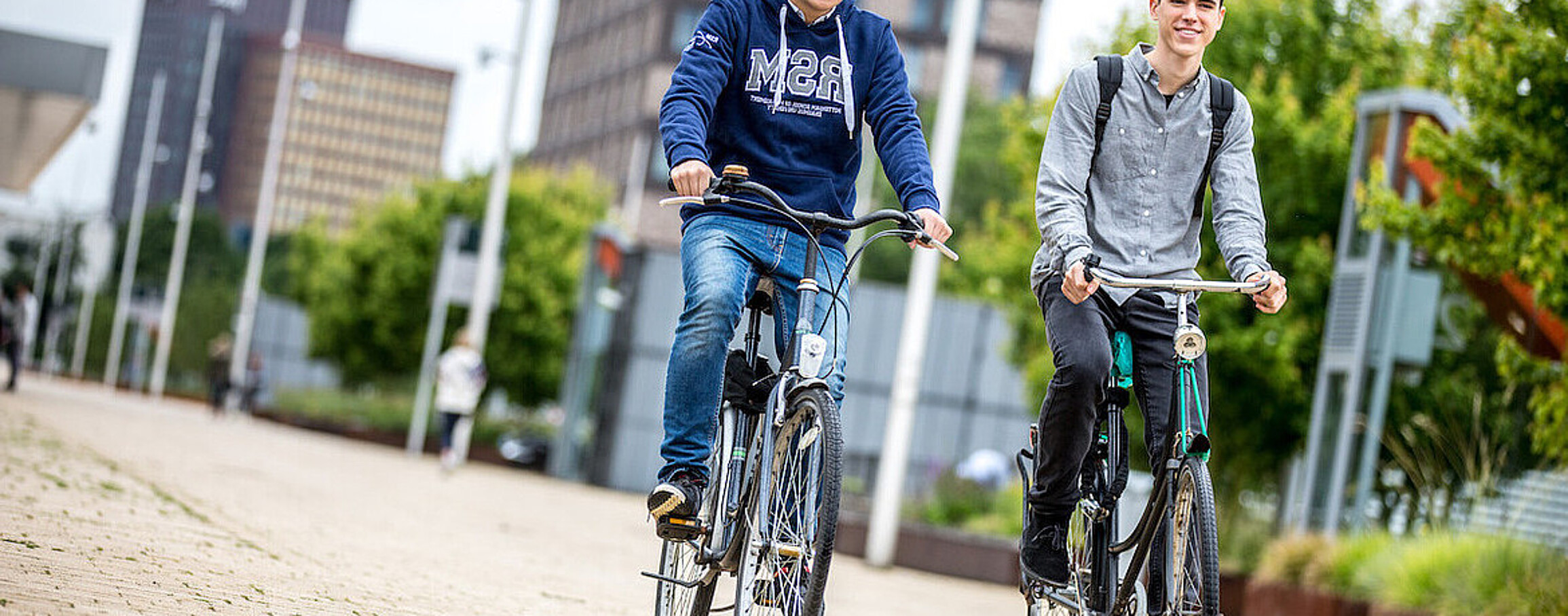 Two students on bikes at RSM