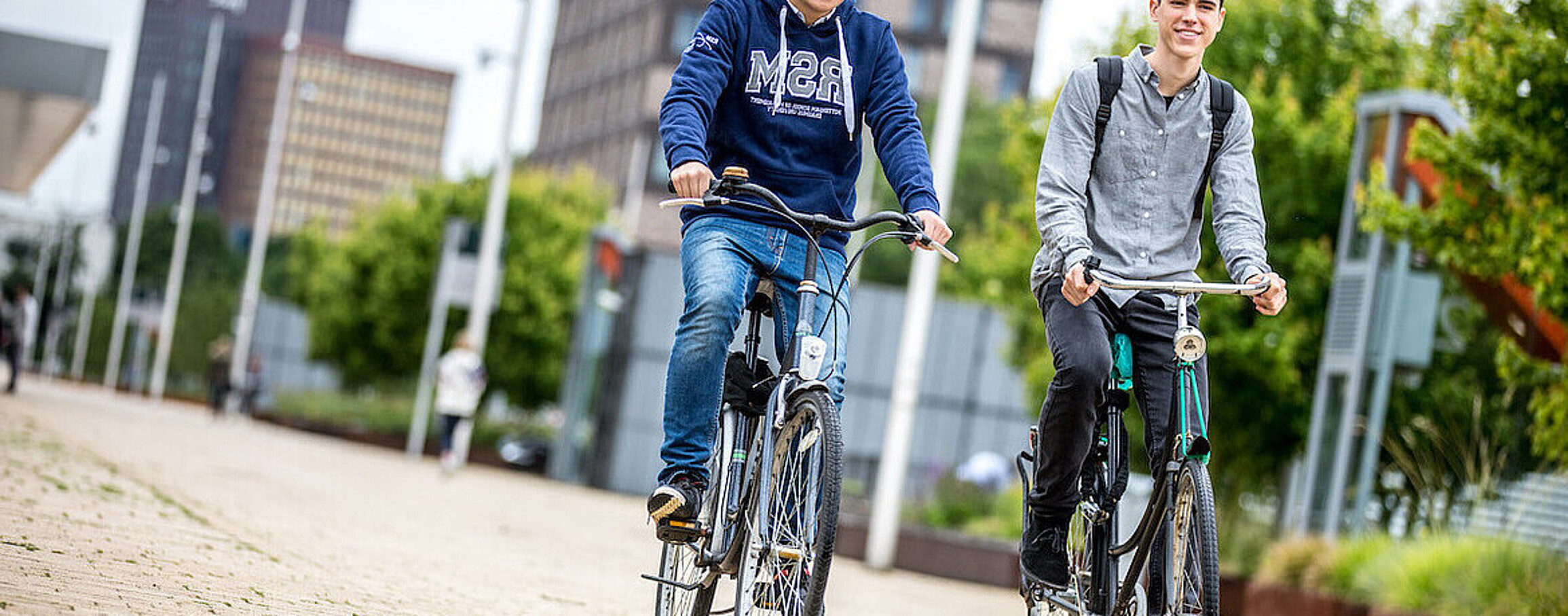 Two students on bikes at RSM