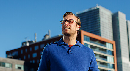A man wearing glasses walking and looking away