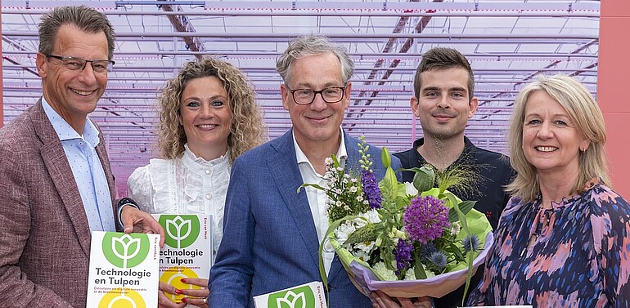 A photo shows five people holding flowers and books Technologie en Tulpen