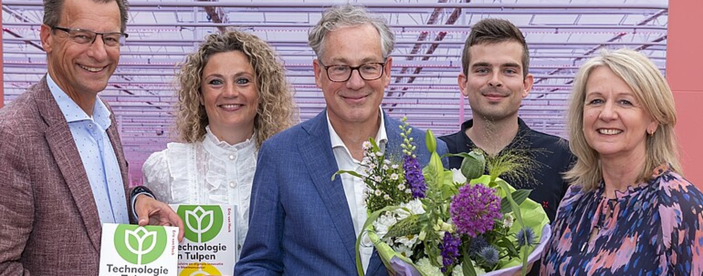 A photo shows five people holding flowers and books Technologie en Tulpen