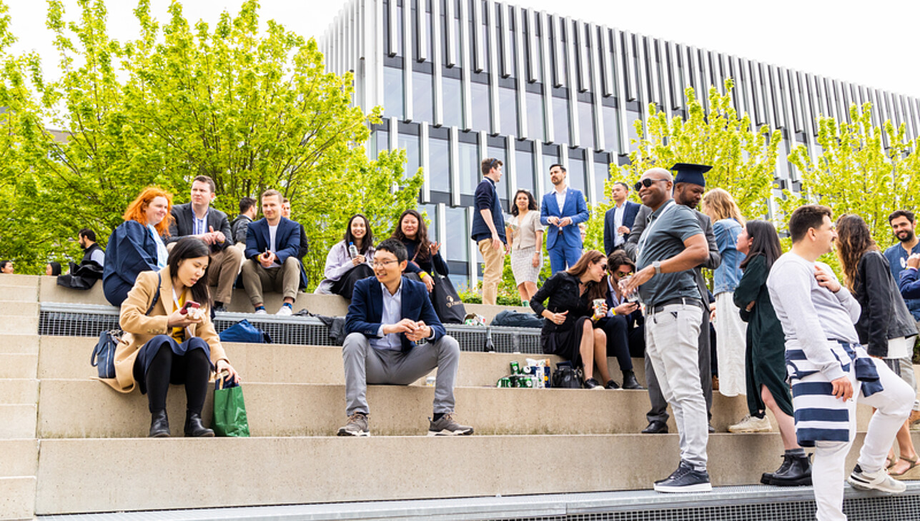 Student sitting down and having fun in front of the Erasmus University campus lake 