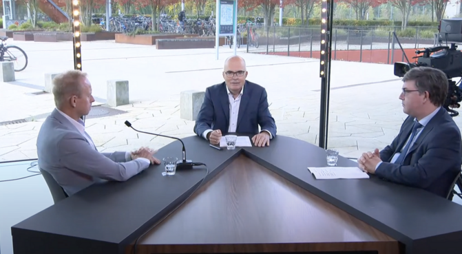 Three people sitting at an interview table