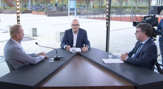 Three people sitting at an interview table