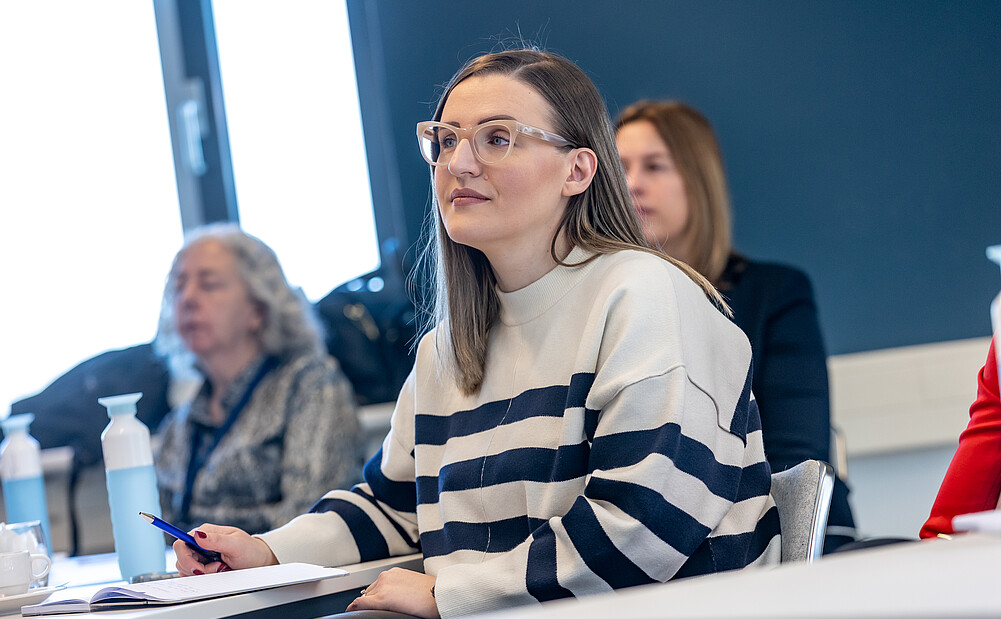Woman sitting listening attentive to a meeting