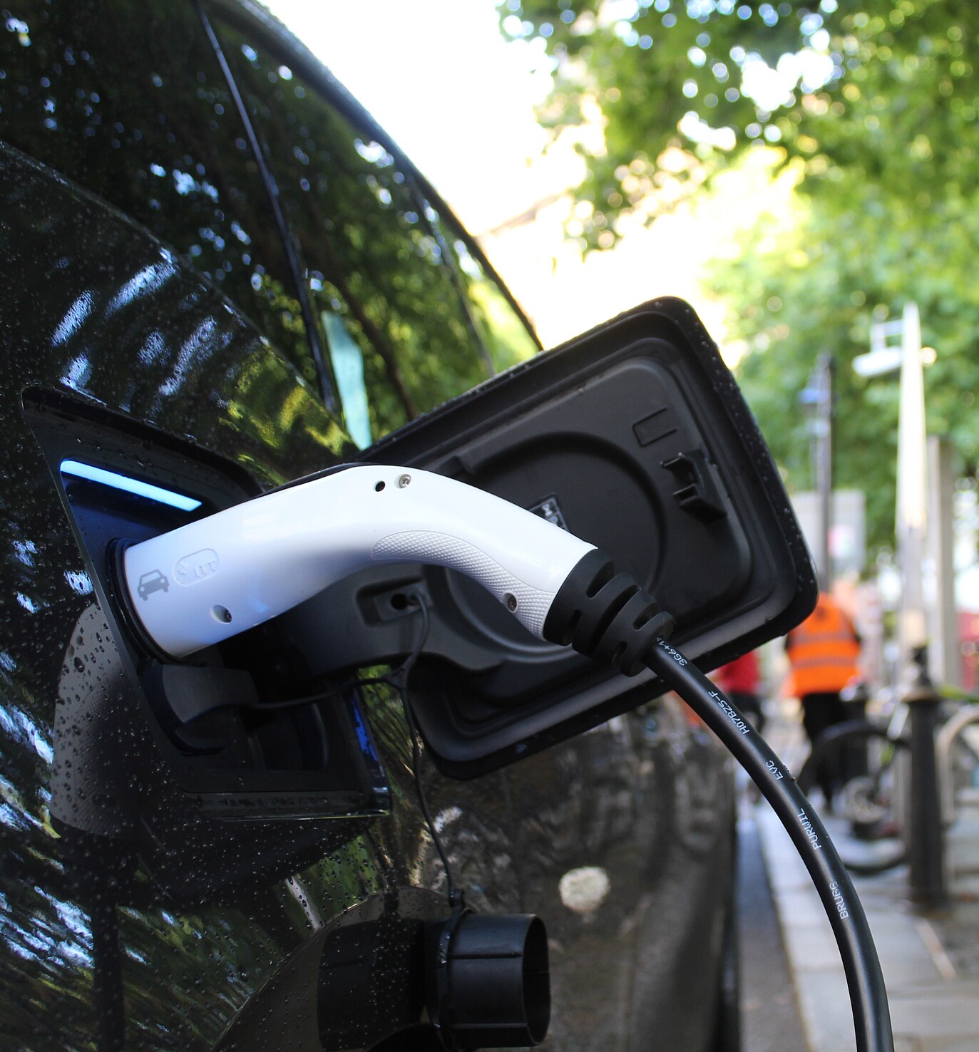 Electric car plugged in and charging at a charging station.