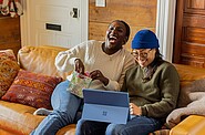 Two people sitting on a couch whilst laughing out loud