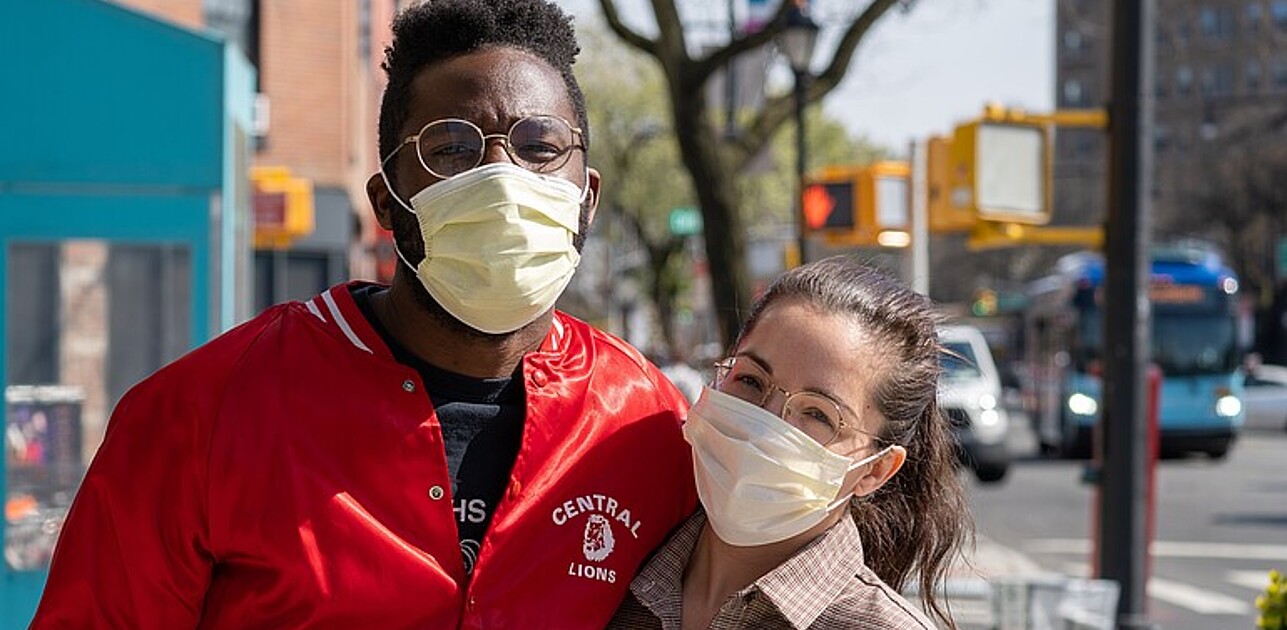 One man and one woman wearing facemasks.