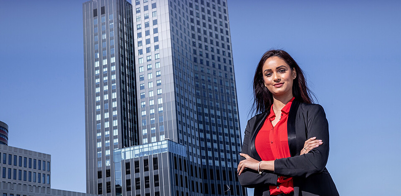 Executive master student standing in front of skyscraper in Rotterdam centrum