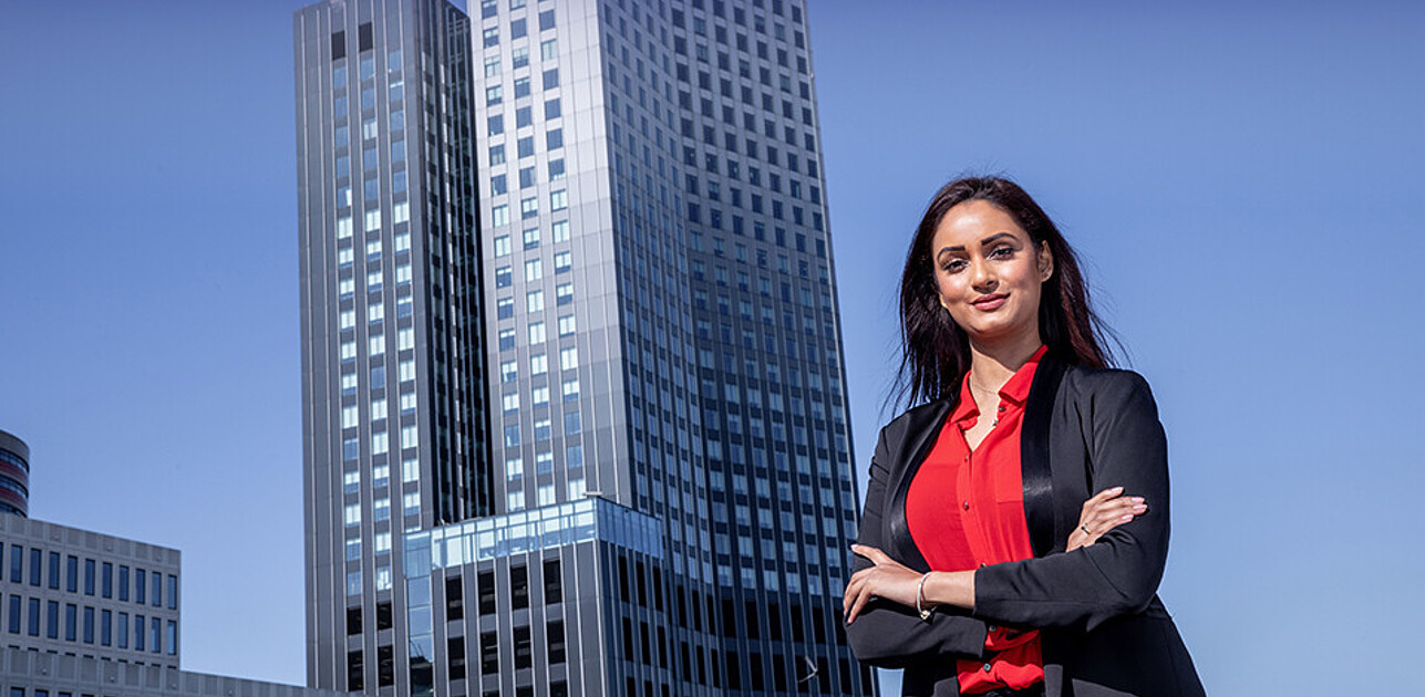 Executive master student standing in front of skyscraper in Rotterdam centrum