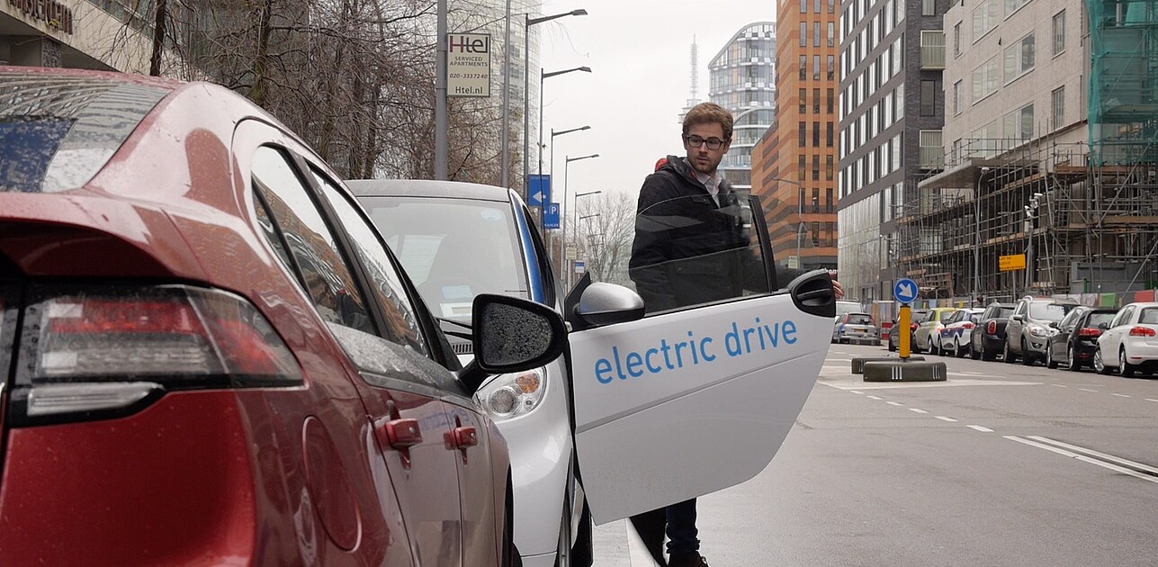 a man stepping out of an eletric car