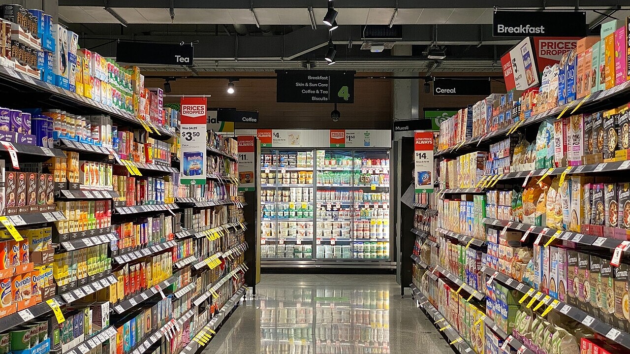 Breakfast aisle in a grocery store with a range of cereals, coffee, and other morning foods and drinkson display.