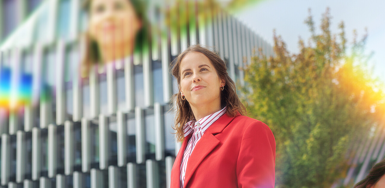 A woman standing at the Erasmus University campus with prisms around her.