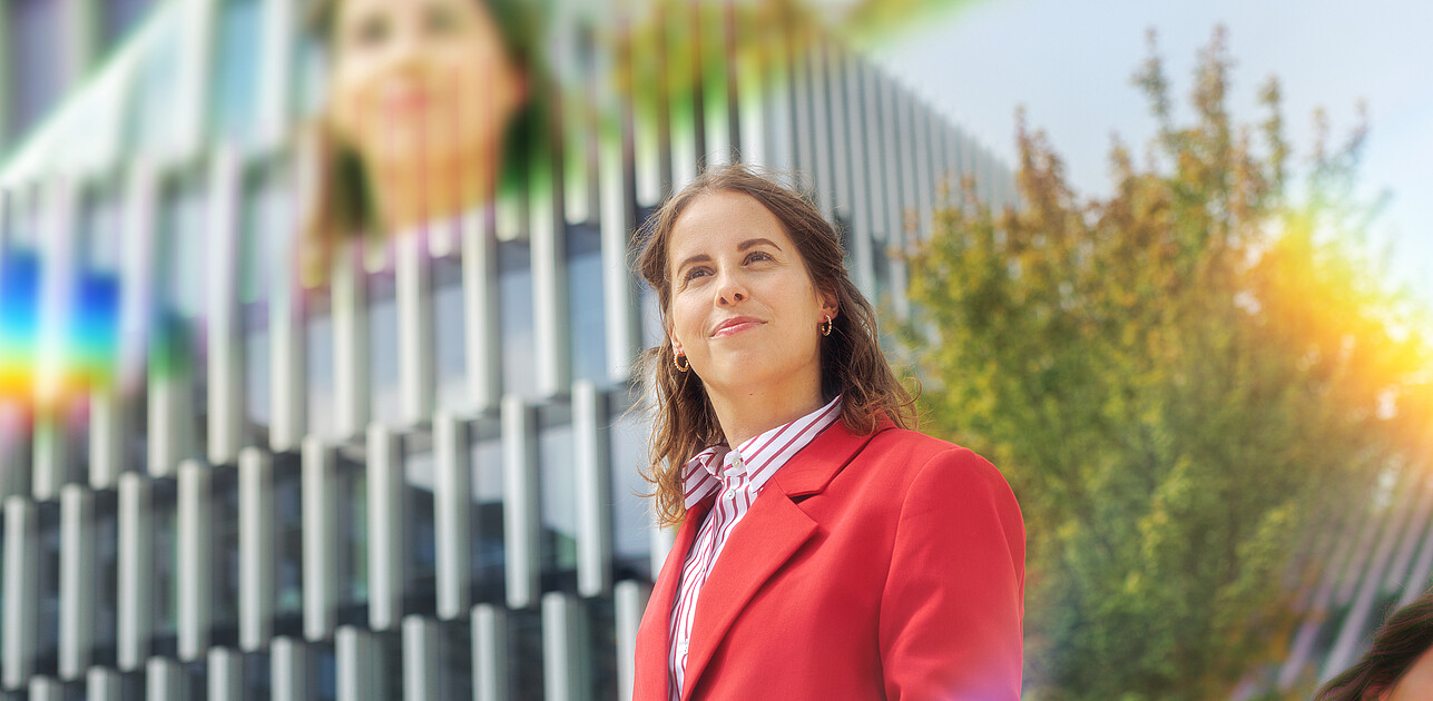Een vrouw op de campus van de Erasmus Universiteit met prisma's om haar heen.