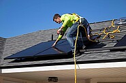 Man on roof installing solar panels