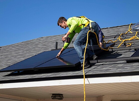 Man on roof installing solar panels