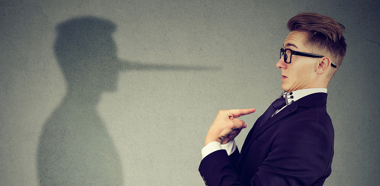 An image shows a surprised man pointing at himself with a dishonest shadow at the background