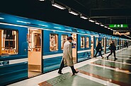 Passengers disembarking from a train onto a quiet platform during off-peak hours.