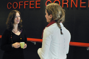 2 colleagues chatting with a cup of coffee in their hands