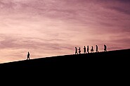 silhouettes of people walking on mountain